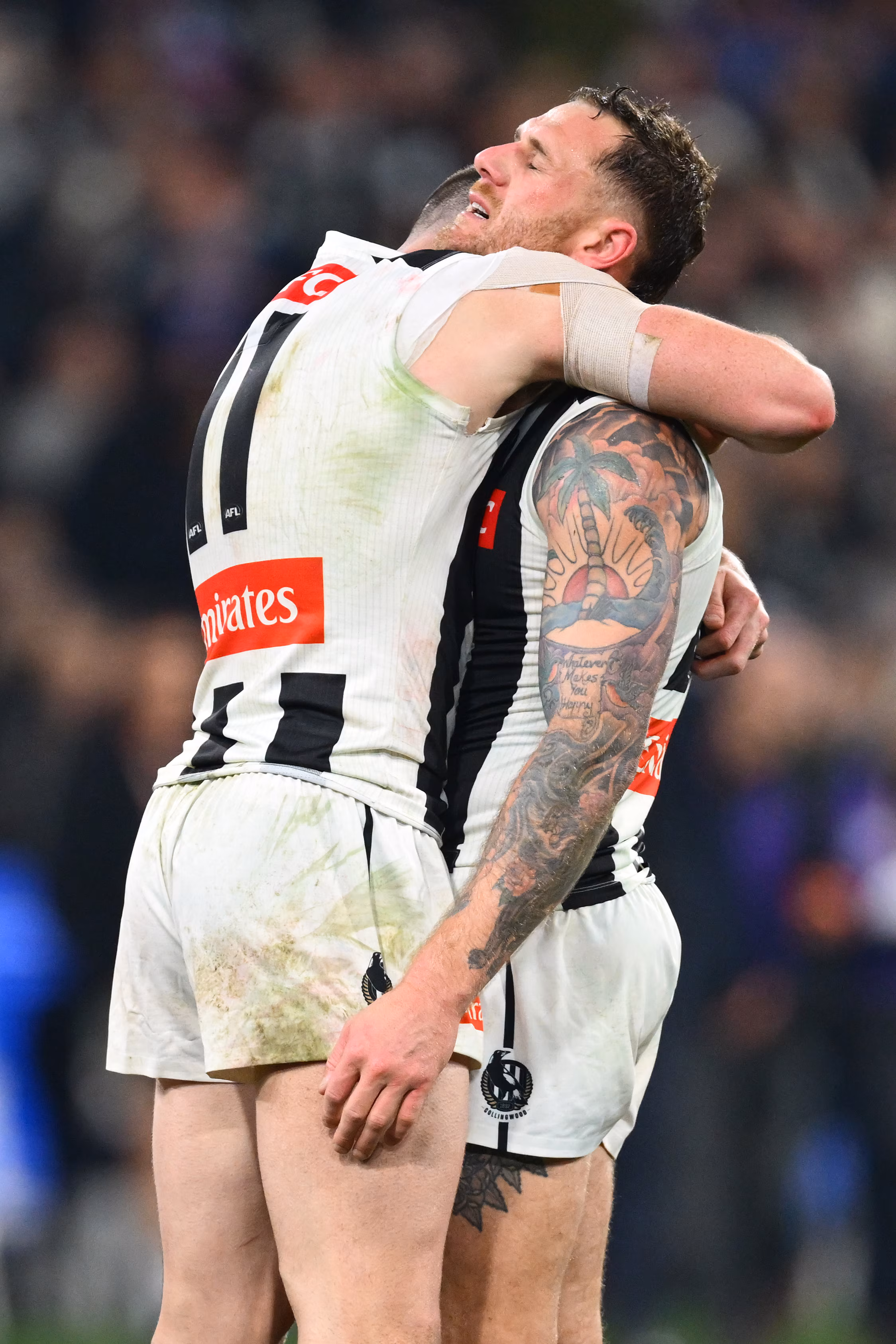 Tim Membrey looks pained as he is hugged by a Collingwood Magpies teammate.