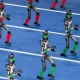 Humanoid robots walk in procession on a blue track