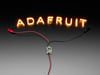 Demo Shot of the Constant Current Boost Converter powering LED Letter Filaments that spell out "Adafruit".