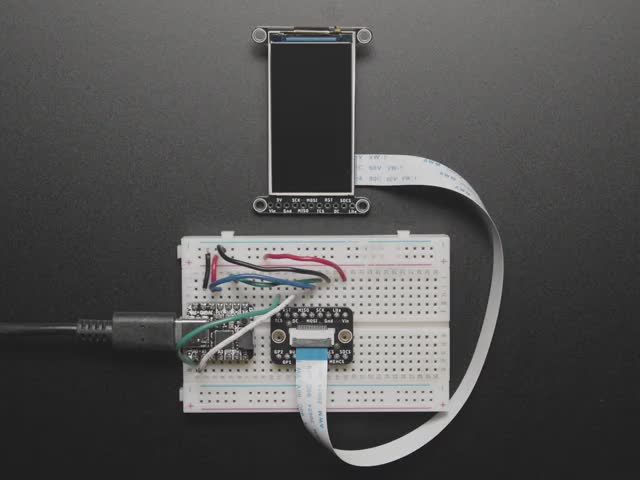 Adafruit EYESPI Breakout Board - 18 Pin FPC Connector - Overhead video of a 1.9" TFT display connected via 18-pin FPC ribbon cable to a square-shaped microcontroller on a breadboard. The TFT plays an animated boot-up demo.