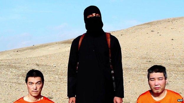 A still of the video appears to show a militant with two hostages