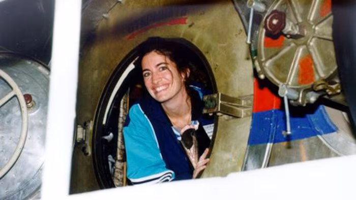 Une femme dont la tête sort d'une capsule spatiale.
